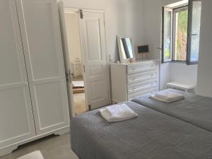 VlachopoulátikaLiz e mao的一间白色卧室,配有一张床和一个梳妆台