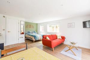 切斯特Charming Chester Studio with private garden & free parking的客厅配有红色的沙发和床。