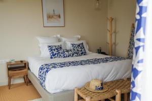 巴尔巴特尔Hôtel Le Noirmoutier的一间卧室配有一张带蓝白色床单的大床