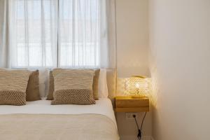 马贝拉Casa Las Palmeras的一间卧室配有一张带窗户和灯的床