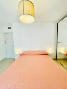 卡利亚里Emme Apartment IUN (Q8410)的一间卧室配有一张带粉红色床罩的床