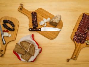 索尔察瓦图里斯梅提葛来阁乡村民宿的一张桌子,上面有带面包和刀的切板