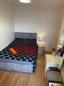 LongfordQuite Broad rest 2的一间卧室配有一张带黑色和橙色棉被的床