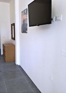 博洛尼亚La Ca' Pezzana Affittaly Apartments的挂在白色墙壁上的平面电视