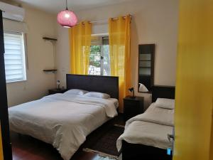 拉马拉Ramallah Hostel的一间卧室设有两张床,窗户配有黄色窗帘