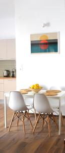 爱琴娜岛Yannis Guest House的白色的用餐室配有桌椅