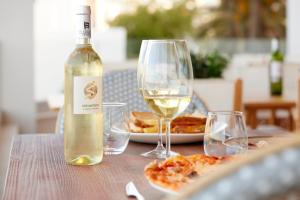 马翁加泰罗尼亚港瞭望台酒店的一瓶白葡萄酒和一张桌子上的两杯酒