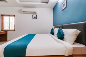 AlipurHotel Stay Inn Maharani Peta的一间卧室配有一张带蓝色墙壁的大床