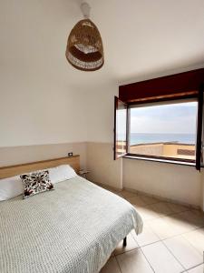 圣塔马里亚迪卡斯特Residenza Fontanelle-Beach Resort的一间卧室设有一张床和一个大窗户