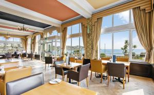 托基理查德森大酒店的餐厅设有桌椅和大窗户。