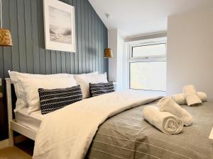 兰迪德诺2 Edward Street的卧室配有带枕头的大床和窗户。