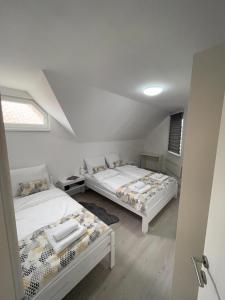 萨拉热窝Guest House Green Field的一间卧室设有两张床和窗户。