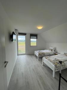 萨拉热窝Guest House Green Field的白色的客房设有两张床和窗户。