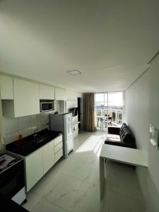 福塔莱萨Aquarius Residence的厨房配有白色橱柜和沙发