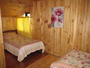 安库德Hostal Austral的小木屋内一间卧室,配有两张床