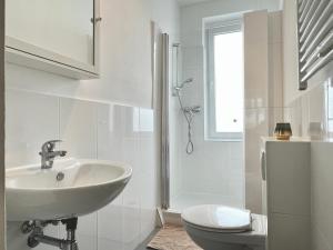 汉诺威Design Apartment - Kingsize Bett - Küche - Zentral的白色的浴室设有水槽和卫生间。