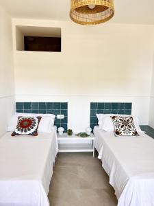 圣塔马里亚迪卡斯特Residenza Fontanelle-Beach Resort的白色墙壁客房的两张床