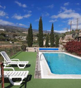 Sabina AltaCasa rural con vistas maravillosas en Arico的游泳池旁设有2把躺椅