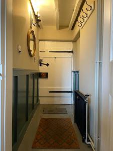 West BrettonWoodpecker Cottage的走廊上设有一扇门,上面有镜子和地毯