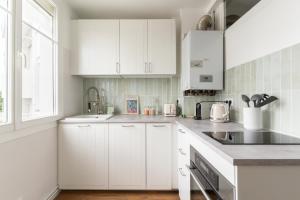 南特Joli Appartement avec Garage sur l'Île de Nantes的白色的厨房配有白色橱柜和水槽