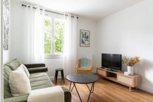 南特Joli Appartement avec Garage sur l'Île de Nantes的带沙发和电视的客厅