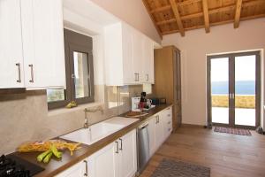 圣尼古拉奥斯Kika Residences的一间厨房,配有白色的橱柜,享有海景