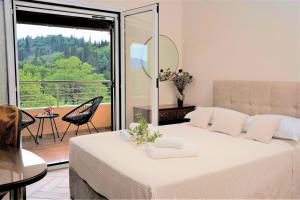 波塔莫斯La Bella Vita - Luxury Holiday House close to Corfu Town的一间带大床的卧室和一个阳台
