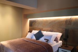 萨图马雷The Dome Aparthotel的一间卧室配有一张带木制床头板的床