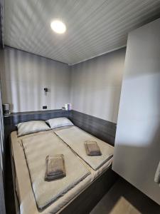 梅特利卡BIG BERRY Kolpa - MerryBerry mobile house的小型客房的一张床位,配有防过敏门控系统