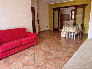 尼科泰拉码头Casa vacanza Amanda的客厅配有红色的沙发和桌子