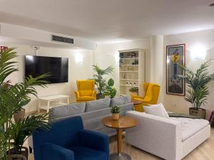 萨拉戈萨AZ Orús Factory Hotel - Parking Gratuíto的客厅配有灰色的沙发和黄色的椅子