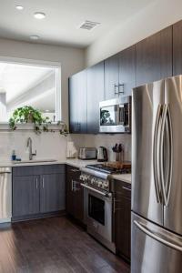 奥斯汀Capitol View Condos by One Fine Bnb - Paramount的厨房配有不锈钢冰箱和木制橱柜