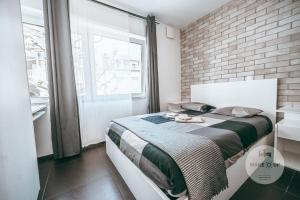 阿尔泽特河畔埃施WakeUp Esch-City的一间卧室设有一张床和砖墙