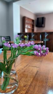 库塔伊西Hotel Max Comfort的花瓶,花朵盛满紫色,坐在桌子上