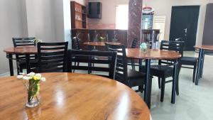 库塔伊西Hotel Max Comfort的餐厅设有木桌和鲜花椅子
