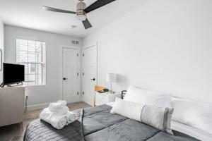 费城Modern Fishtown Townhouse的白色卧室配有床和吊扇