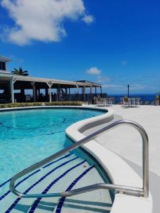 Dickenson Bay特雷德文斯酒店的蓝色海水和椅子以及海洋的游泳池