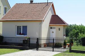 沙罗什保陶克Braun vendégház的一间白色的小房子,设有黑色的围栏