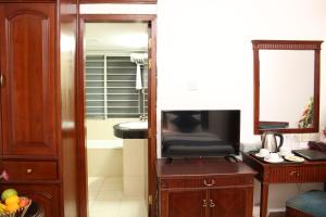 达卡Hotel West Valley Dhaka的带电视的客厅和带浴缸的浴室。