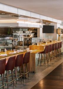 达拉斯Sonder at Commerce的餐厅设有长长的酒吧,配有凳子