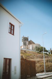 劳林哈Casa do Castelo的一座白色的建筑,后面有一座城堡