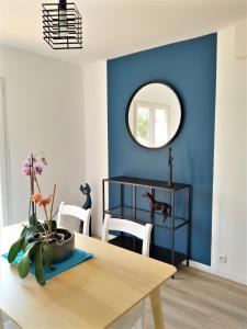 拉隆德莱丝莫里斯Superbe bas de villa 80 m2 très calme et frais avec vue magnifique 6 couchages的一间拥有蓝色墙壁和一张带镜子的桌子的用餐室