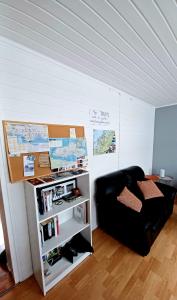 特罗姆瑟Tromso Coco Apartments in Center的客厅配有黑色沙发和书架