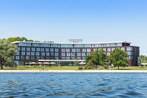 沃尔夫斯堡沃尔夫斯堡万怡酒店的靠近水体的红色大建筑