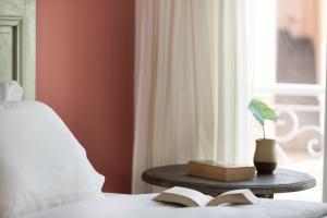 提诺斯蒂诺斯度假酒店的一张桌子上的床,靠窗边的书
