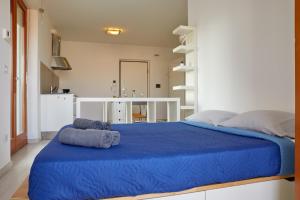西维尔诺瓦·马尔凯Moderno Monolocale in Città con Parcheggio privato的一间卧室配有蓝色的床和蓝色的毯子