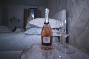 巴里Arco Alto Rooms的桌子上放有一瓶葡萄酒和两杯酒