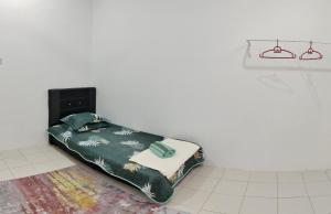 关丹FS Homestay Cherating的白色客房的一张床位,配有绿毯