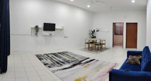 关丹FS Homestay Cherating的客厅配有蓝色的沙发和电视