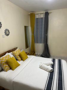 尼耶利Ruby Modern Homes-1br-Nyeri, King'ong'o-Marriott的一间卧室配有一张大床,提供黄色和蓝色的枕头